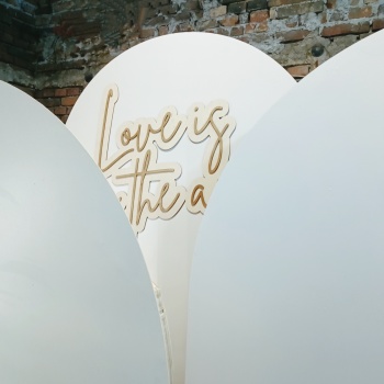 stylowa ścianka do zdjęć z napisem Love is in the air | Dekoracje ślubne Kraków, małopolskie
